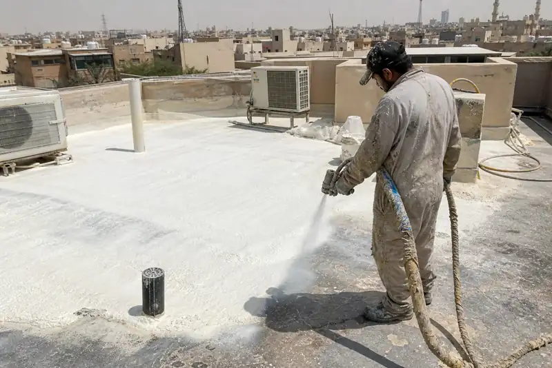 عامل ينفذ رش عزل فوم على سطح خرساني مستخدم في الرياض